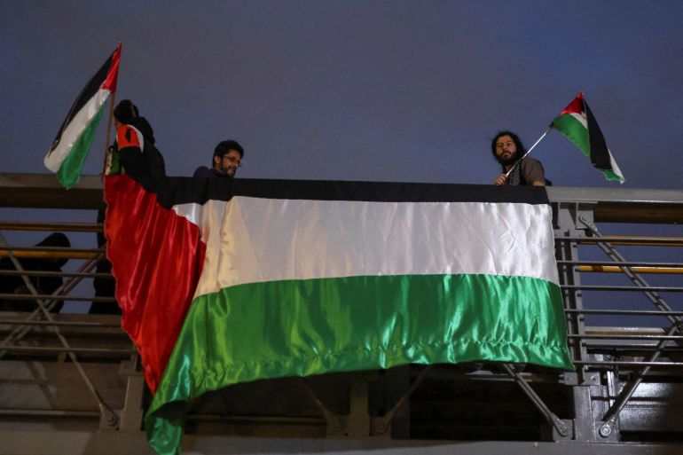 ناشطون يرفعون علم فلسطين على مبنى السفارة الإسرائيلية في كولومبيا (رويترز)