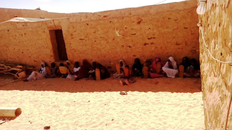 البنات يجلسن في الظل بفناء المنزل لعدم وجود حجرة تؤويهن